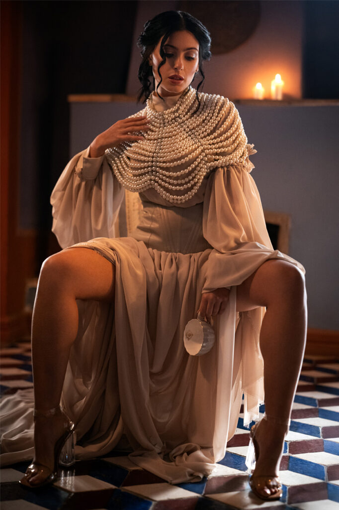 Model in flowing gown by candlelight, high-end editorial retouch, cinematic tones