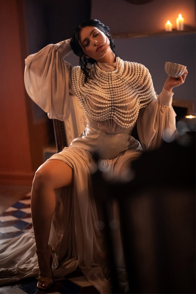 Model in flowing gown by candlelight, high-end editorial retouch, cinematic tones