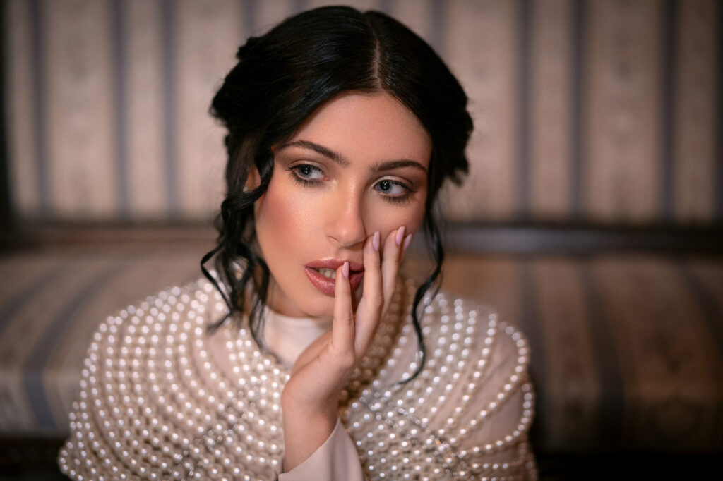 Portrait of woman with pearl garment, skin retouching, cinematic vintage look